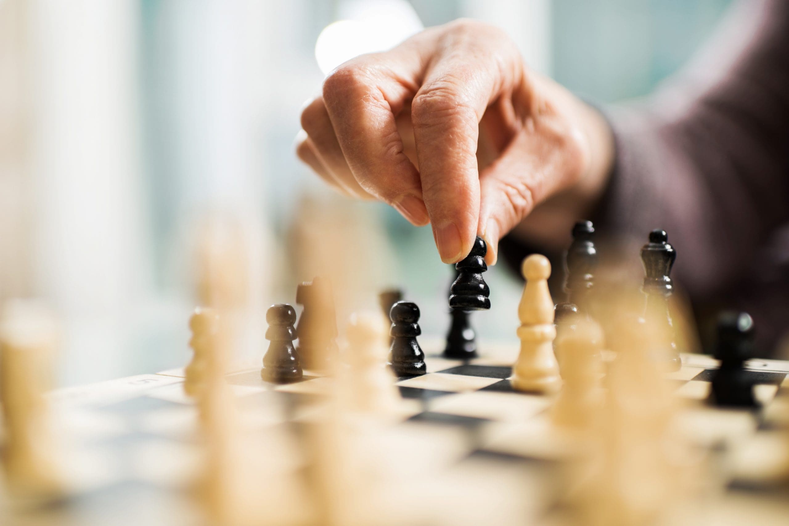 Unrecognizable senior person playing chess at Quartet Senior Living