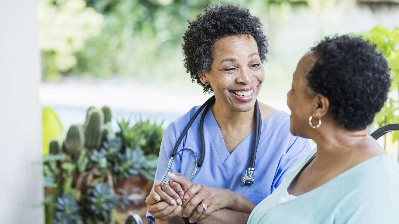 Senior woman sitting and smiling with her caregiver
