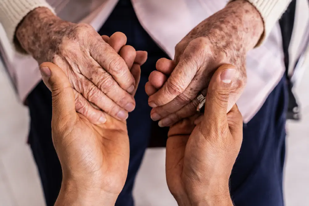 close up of a senior holding hands with their caregiver