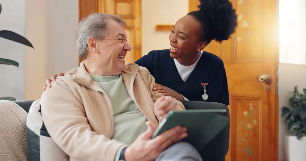 Smiling caregiver engaging in joyful conversation with senior man at Quartet Senior Living in Bettendorf, Iowa