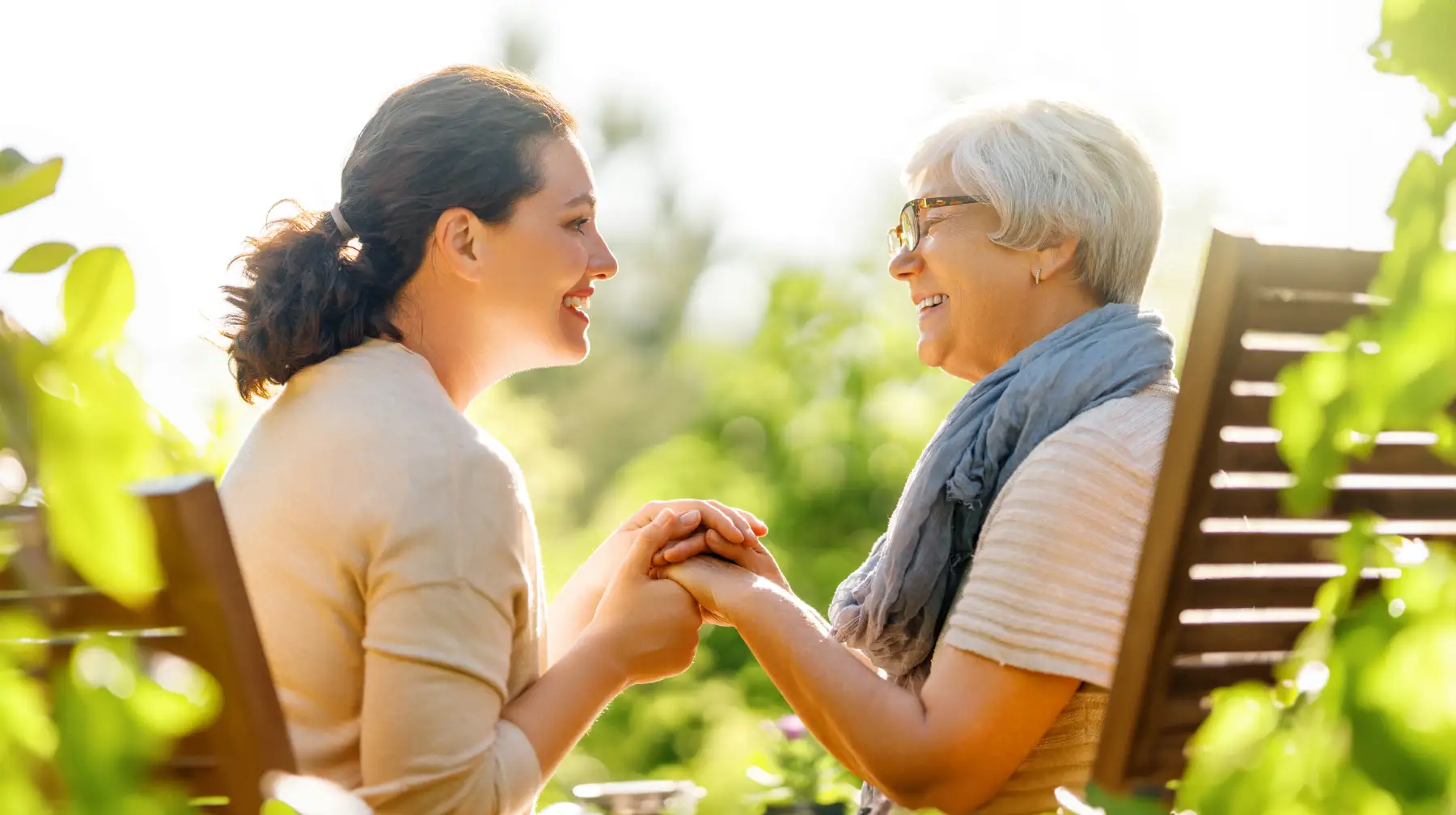 iStock-2057205826 a senior woman and her adult daughter holding hands and smiling