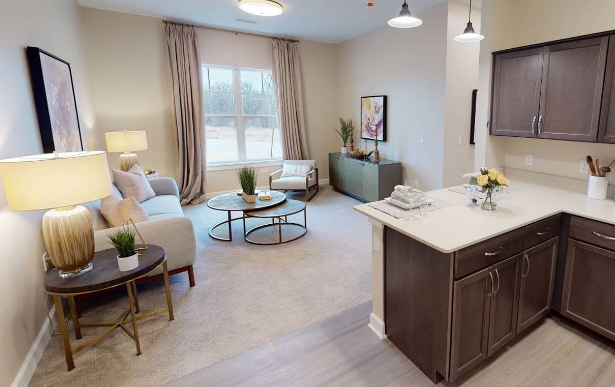 assisted-living-apartment-interior-quartet Spacious Assisted Living apartment with modern kitchen and cozy seating at Quartet Senior Living in Bettendorf.