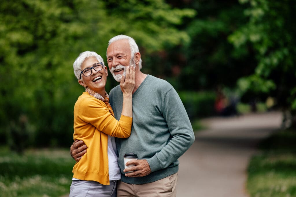 Senior couple holding each other on walking path 