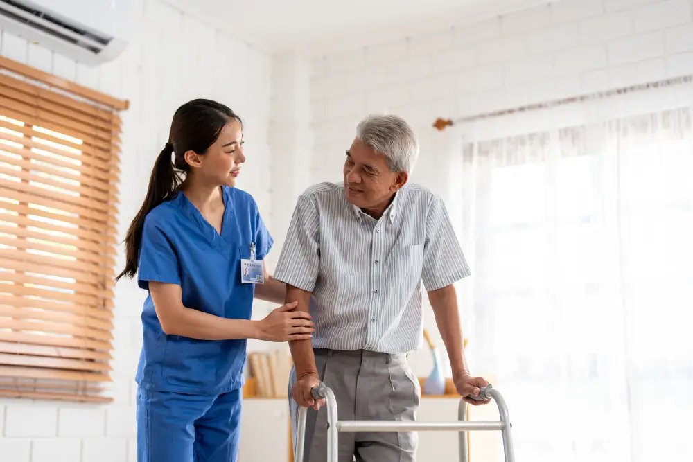 Nurse helping senior man walk with a mobility aid at Quartet Senior Living in Bettendorf, Iowa