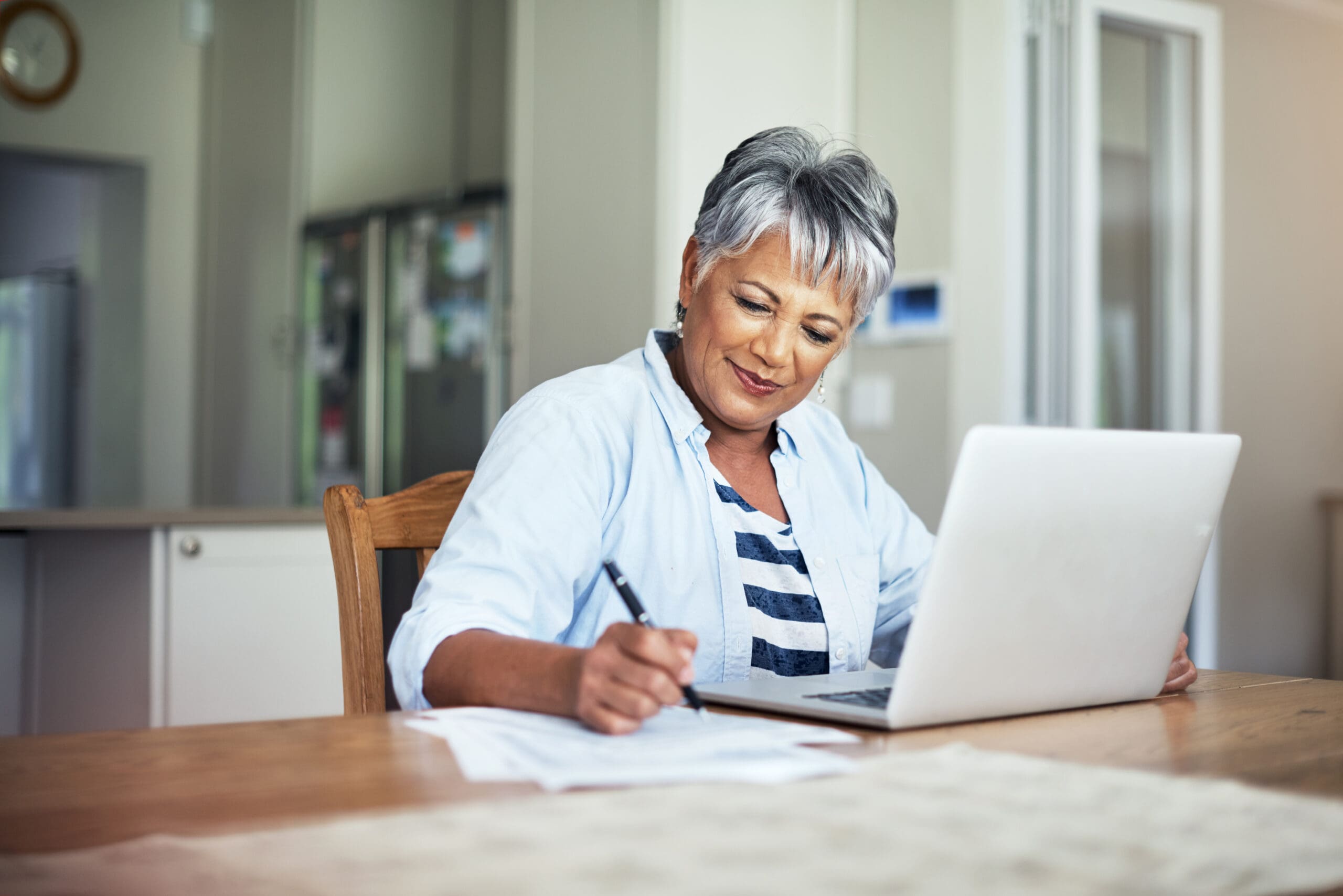 She’s budgeted well An elderly woman reading a blog about financial planning tips for seniors at Quartet Senior Living.