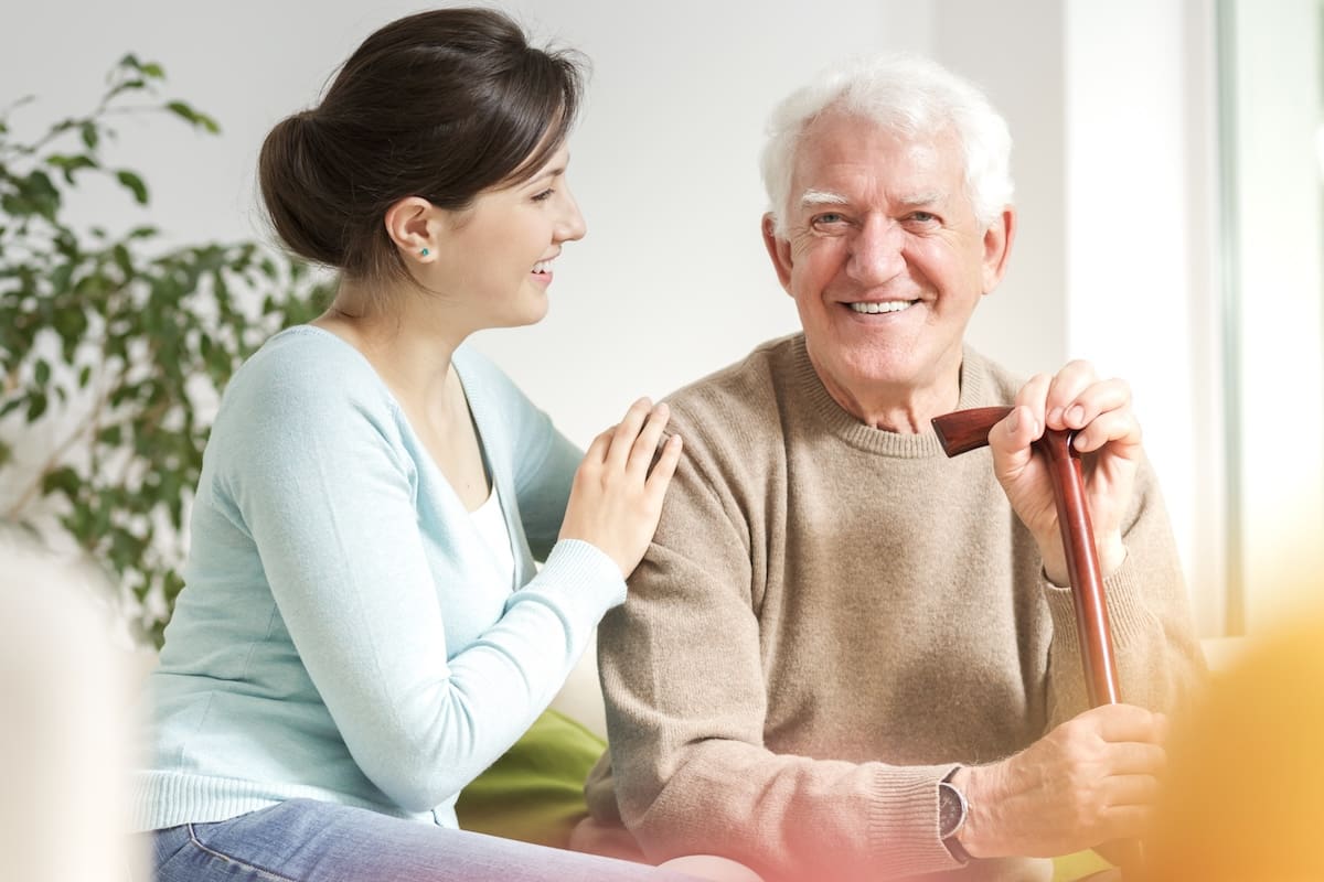 Happy,Woman,Supporting,Smiling,Senior,Man,With,Walking,Stick Support in Assisted Living